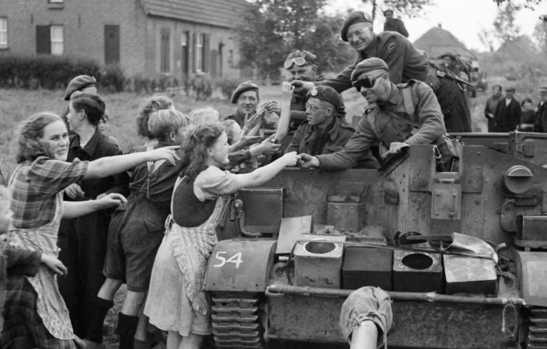 A carrier crew of 8th Rifle Brigade hands out chocolate to Dutch civilians during the advance of 11th Armoured Division in Holland, 22 September 1944.