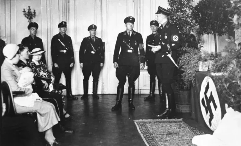 Photo showing a child's baptism (christening) ceremony/ritual; conducted by members of the SS at a "Lebensborn e.V." maternity care home in Rheinhessen