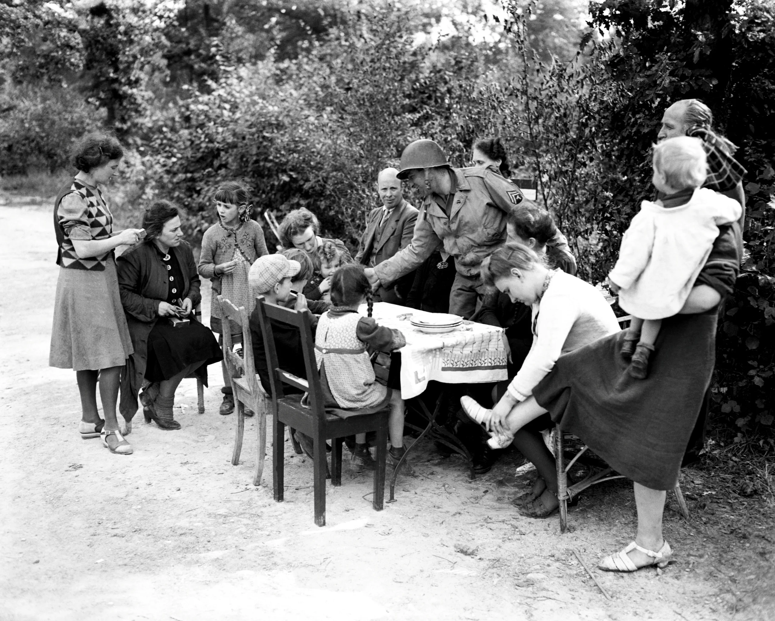 15th September 1944 TOPFOTO CODE: PD3001327 Americans give rations to Germans. In the German town of Herzogenrath, eight miles North of Aachen and only 40 Miles from Cologne, Cpl. Mel White, of Harlan, Iowa, gives American rations to a large German family. © Topfoto / Peter Deleuran | Used with exclusive permission.