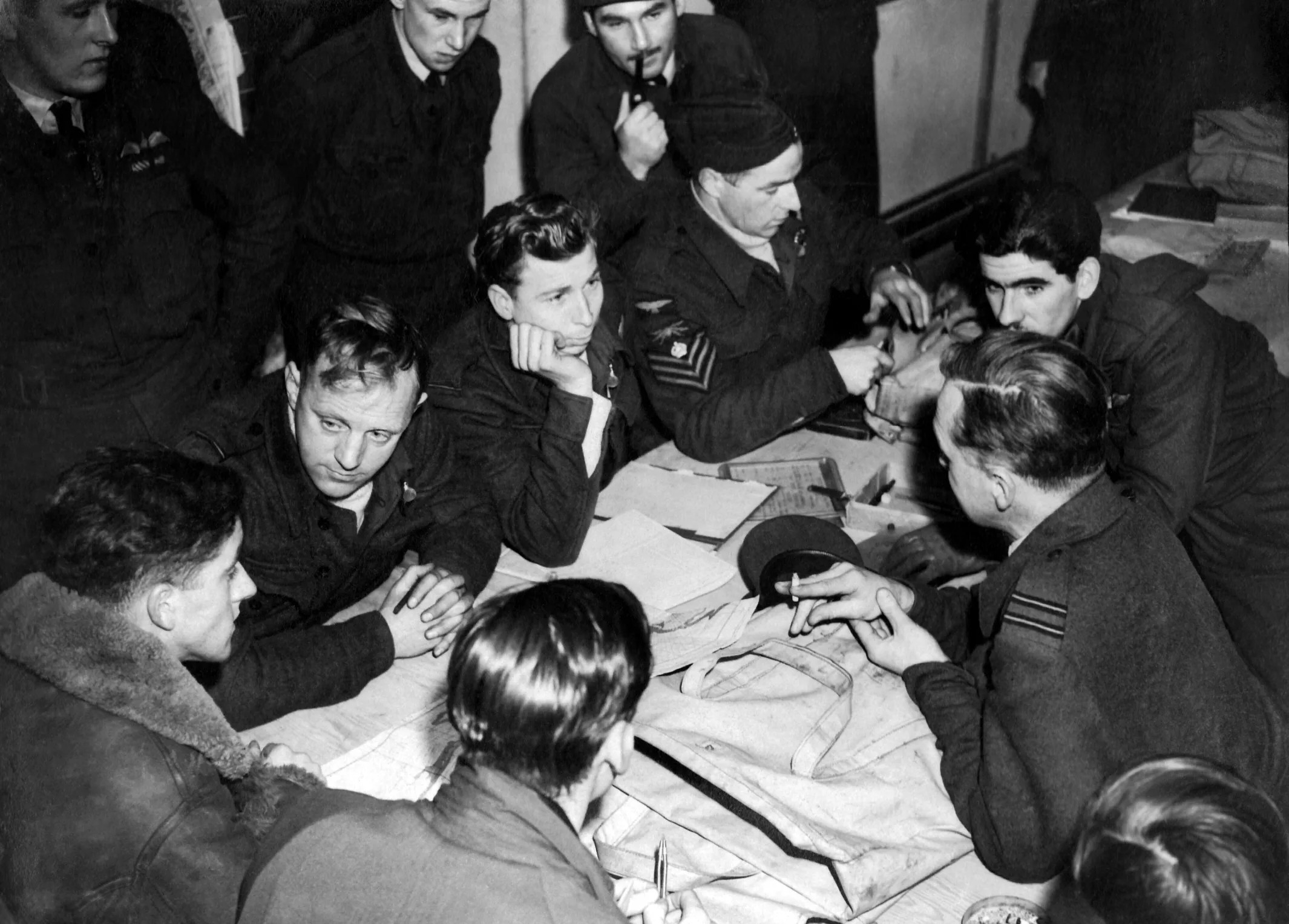 6th December 1944 TOPFOTO CODE: PD3001191 Incessant attacks by Coastal Command forced the Germans to run their North Sea convoys under cover of darkness, and now the Shipfinder Force of Coastal Command has made night almost as hazardous as day for Nazi vessels. Flares of immense candle-power are dropped by Wellington bombers, silhouetting the targets for other Wellingtons or Beaufighter strike forces, which attack in powerful formations. Shipfinder Force has made more than 100 attacks since D-Day, and while the nature of the new tactics makes observation of results difficult, it is known that many direct hits have been scored on enemy shipping. PHOTO SHOWS:- After being briefed for a night attack on German shipping, a Coastal Command Shipfinder Force crew makes final arrangements before setting out in search of the enemy. (Gaiger Planet Dec, 6 1944 PN Censor No. 376622 © Topfoto / Peter Deleuran | Used with exclusive permission.