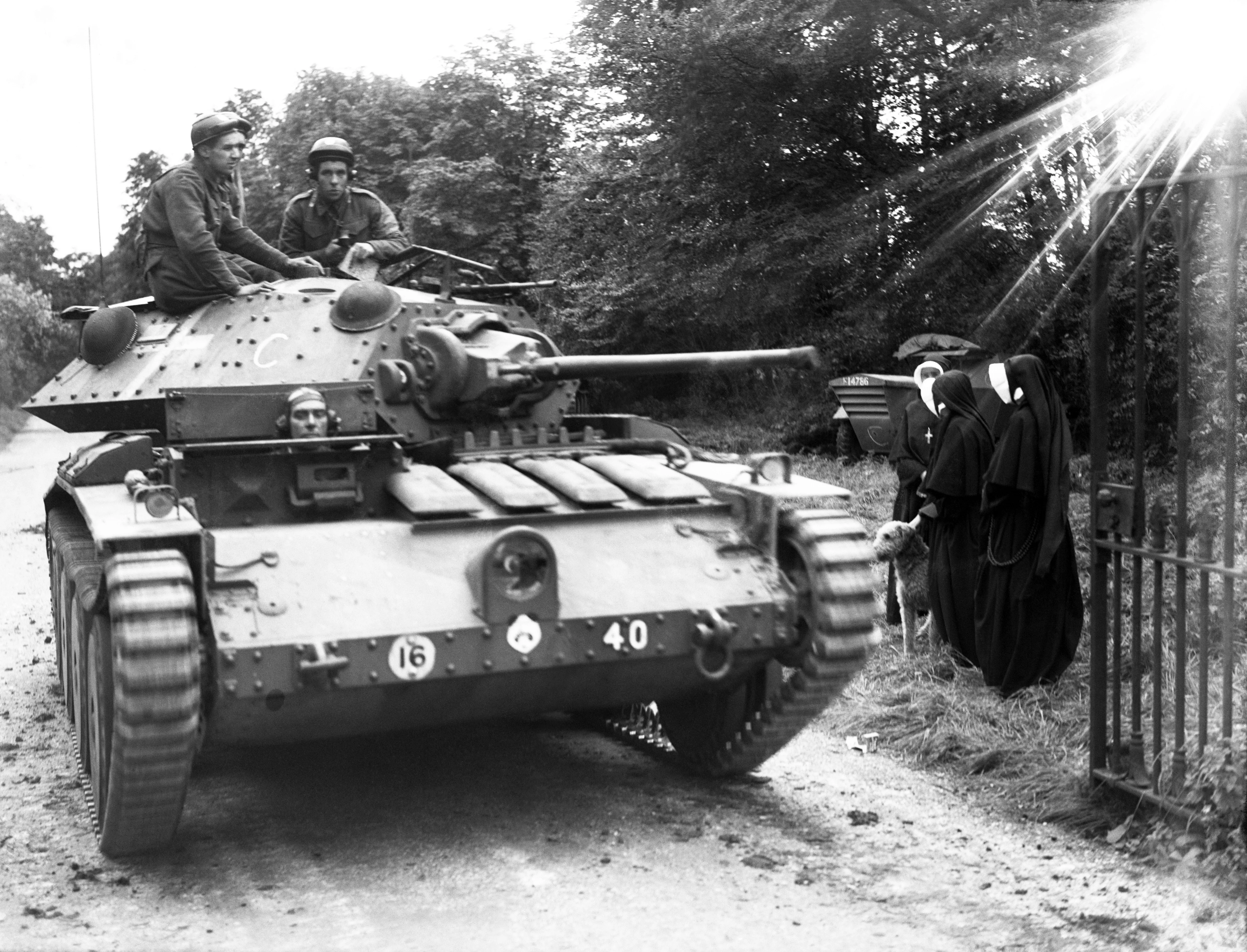 1941 TOPFOTO CODE: PD3001509 A defending tank passes some nuns by the roadside. Members of a tank crew pause on a country road to chat with a group of nuns, out for a walk with their dog, during a break in manoeuvres held in England. © Topfoto / Peter Deleuran | Used with exclusive permission.
