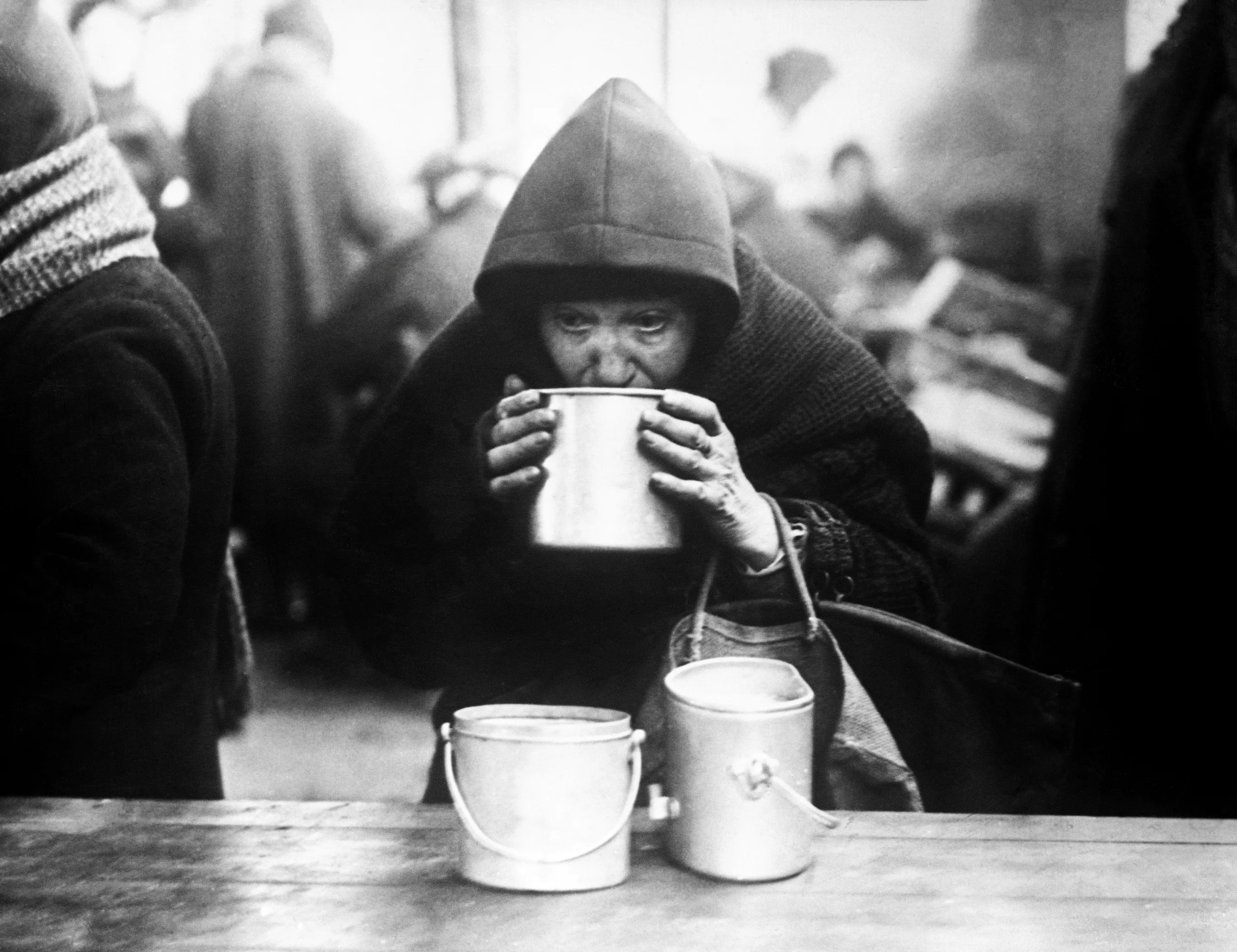 30th January 1945 TOPFOTO CODE: PD3001261 The municipality of Noisy-Le-Sec has instituted special kitchens where 1100 hot meals are served daily to the aged and bombed out. Most of the people have no means of heating at all. Photo shows:- An old woman enjoys a tin of hot soup at the kitchen. © Topfoto / Peter Deleuran | Used with exclusive permission.