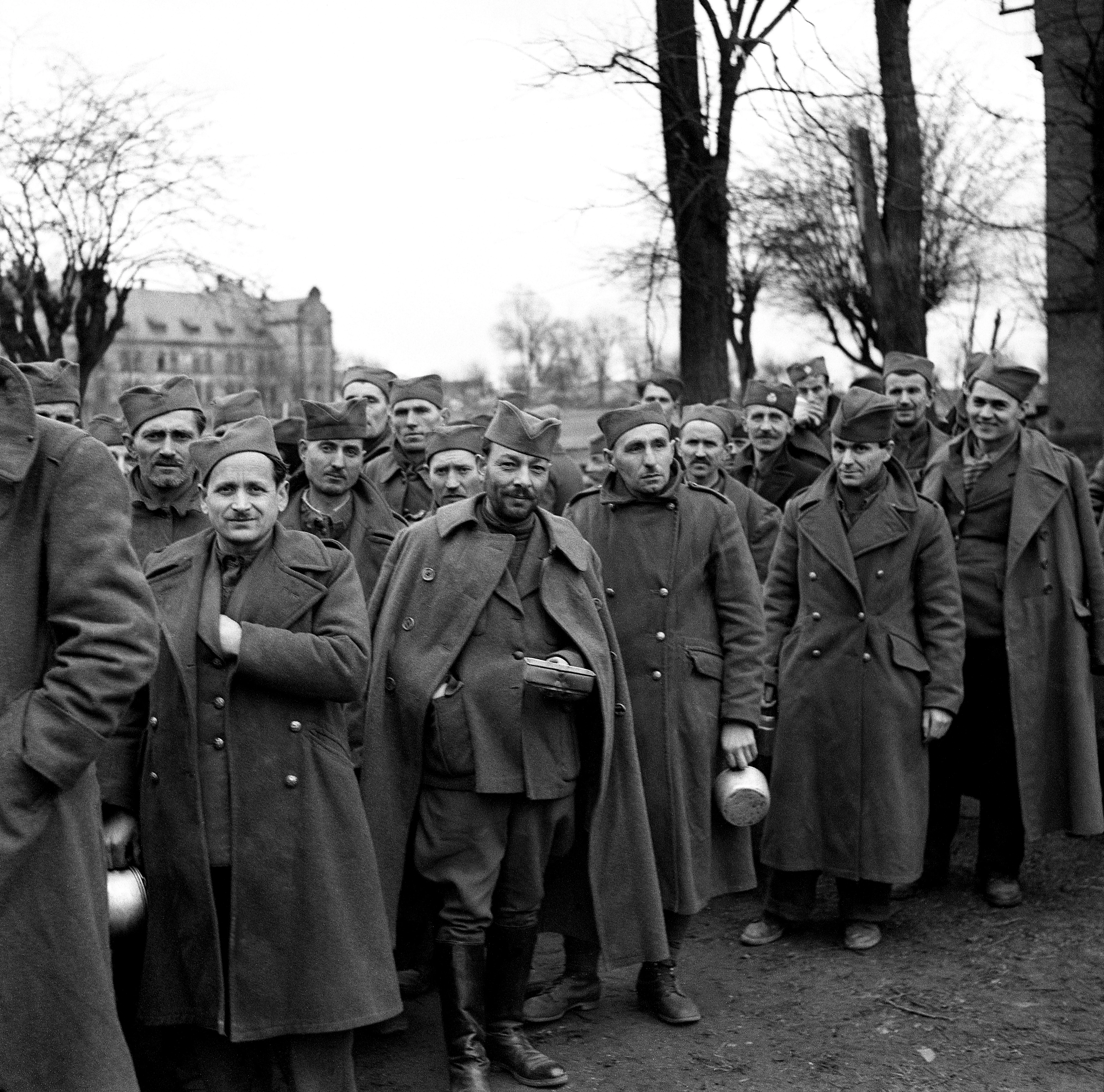 11th March 1945 TOPFOTO CODE: PD3001360 A group of Yugoslavs among the released prisoners; they are queuing for their first hot meal for many months. © Topfoto / Peter Deleuran | Used with exclusive permission.
