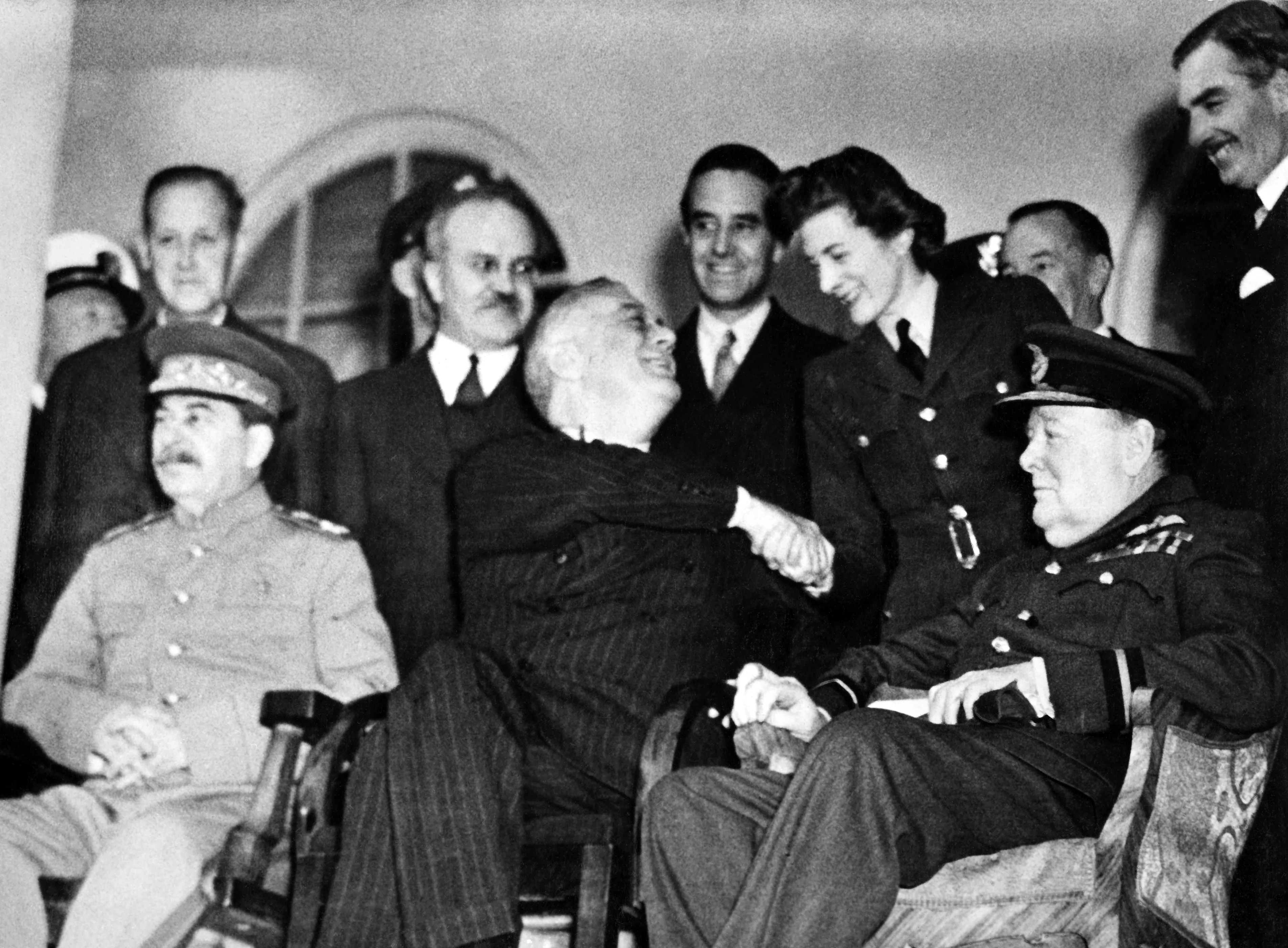 Nov/Dec 1943 TOPFOTO CODE: PD7493834 Allied leaders and members of their staffs at historic Tehran conference. Seated between Marshal Joseph Stalin (left) Russian Premier, and British Prime Minister Winston Churchill, President Franklin D Roosevelt of the U.S. shakes hands with Section Officer Sarah Oliver of the British Women’s Auxiliary Air Force, daughter of Mr. Churchill, outside the Russian Embassy at Tehran, Iran, where historic conferences were held completing plans for the destruction of the German military forces. Behind the Allied leaders are, left to right: Harry L. Hopkins, Special Assistant to President Roosevelt; Vyacheslav M. Molotov, Russian Foreign Commissar; W. Averell Harriman, U.S. Ambassador to Russia, and at the extreme right Anthony Eden, British Foreign Secretary. APPROVED BY APPROPRIATE U.S. AUTHORITY (U.S Office of War Information picture/Library of Congress, Prints & Photographs Division, Farm Security Administration/Office of War Information Black-and-White Negatives) © Topfoto / Peter Deleuran | Used with exclusive permission.