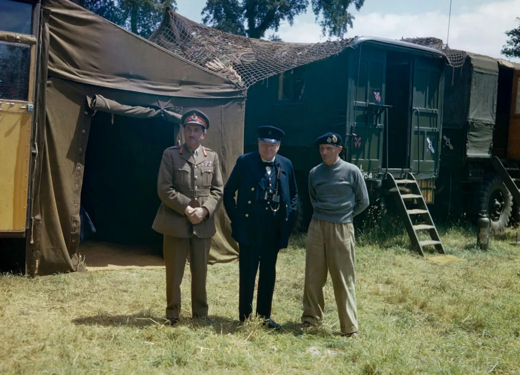 Winston Churchill flanked by the Chief of the Imperial General Staff, Field Marshal Sir Alan Brooke and General Sir Bernard Montgomery, commanding 21st Army Group, at Monty's mobile headquarters in Normandy. June 12, 1944.